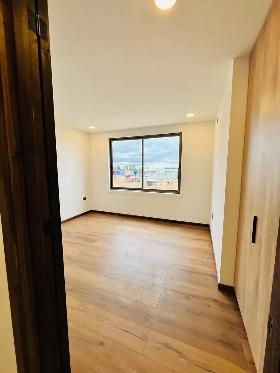 Dormitorio con ventana y piso flotante — Parcela 1, Parcela con casa nueva