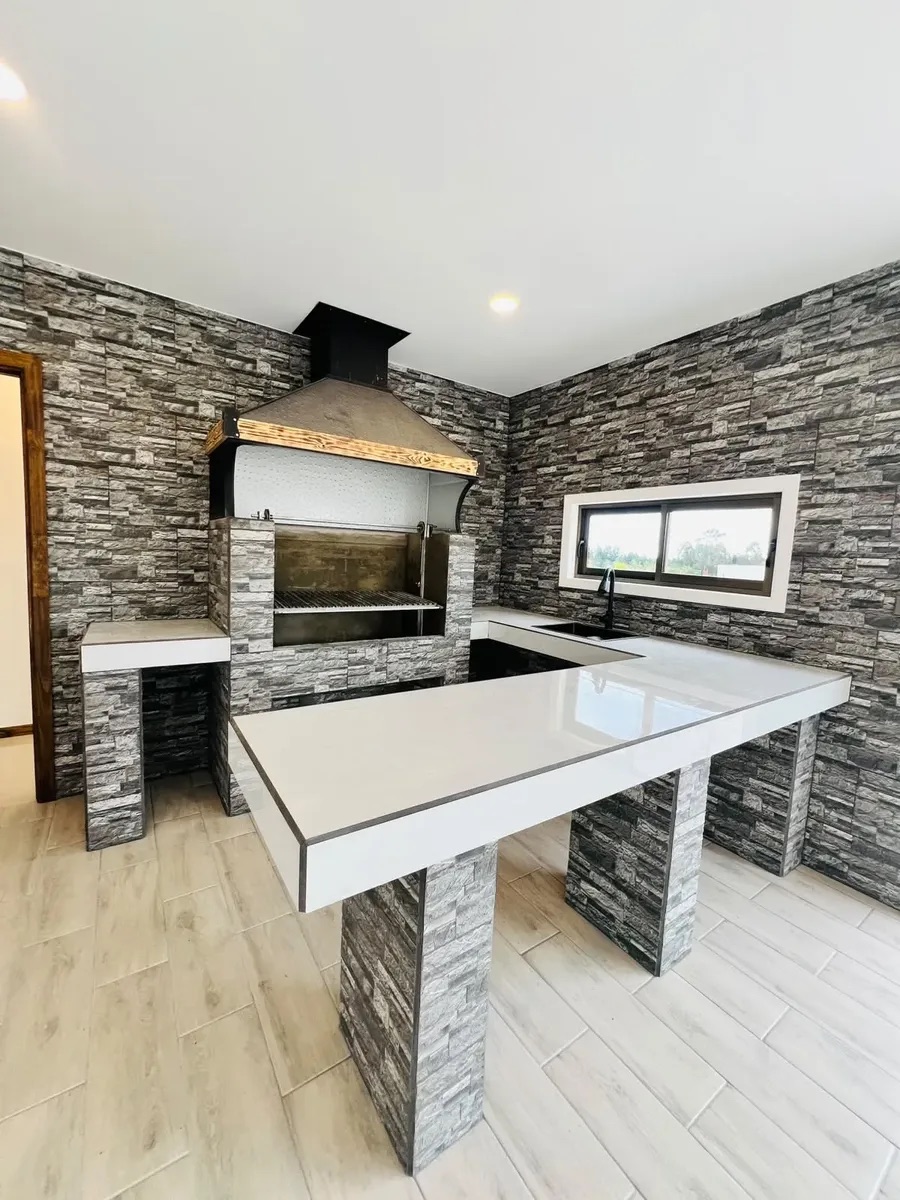 El quincho cerrado con la parrilla de obra y el mesón — Parcela 1, Parcela con casa nueva