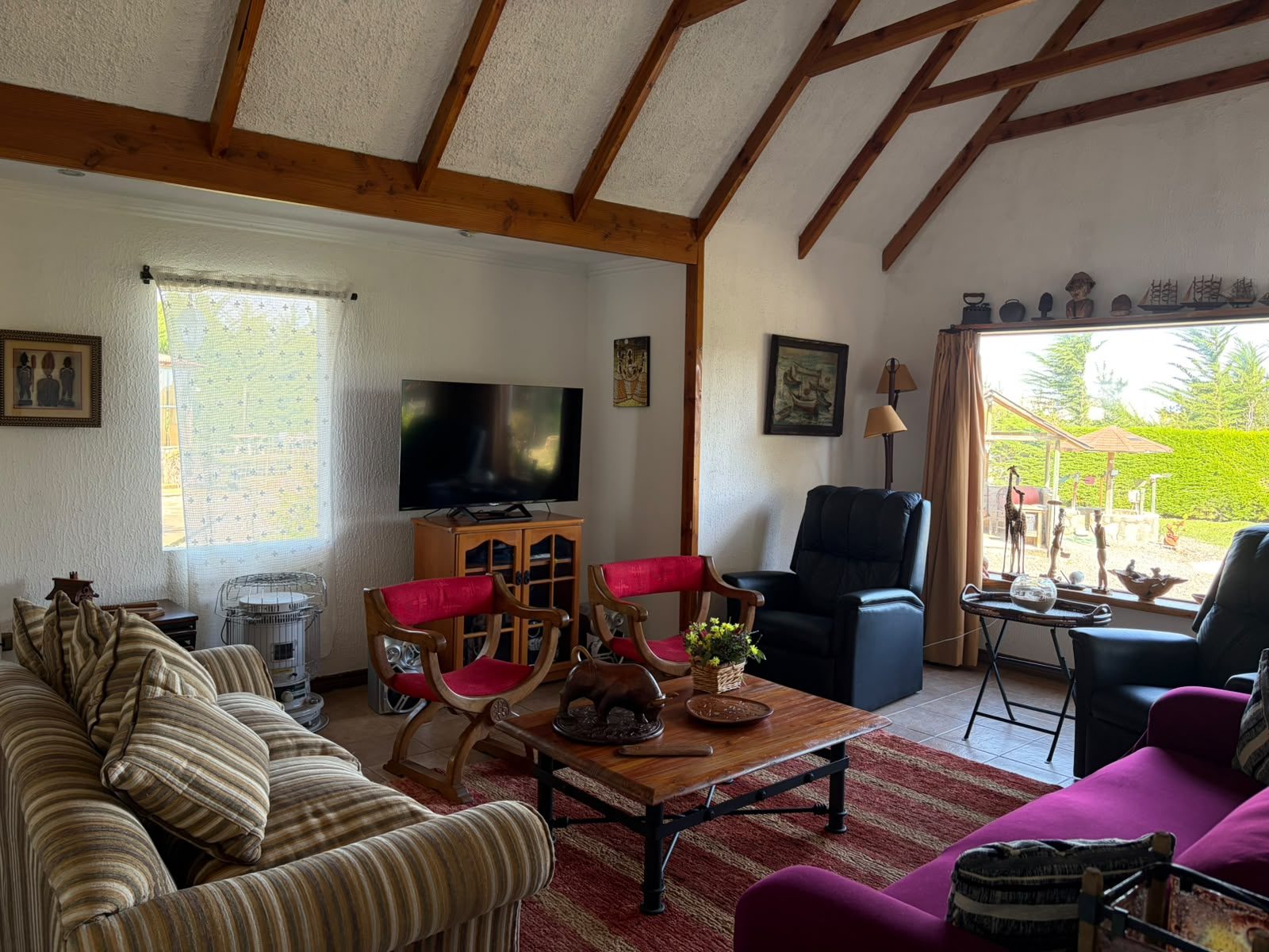 El living con techo de vigas a la vista y ventanal al jardín — Parcela 1, Parcela familiar con piscina